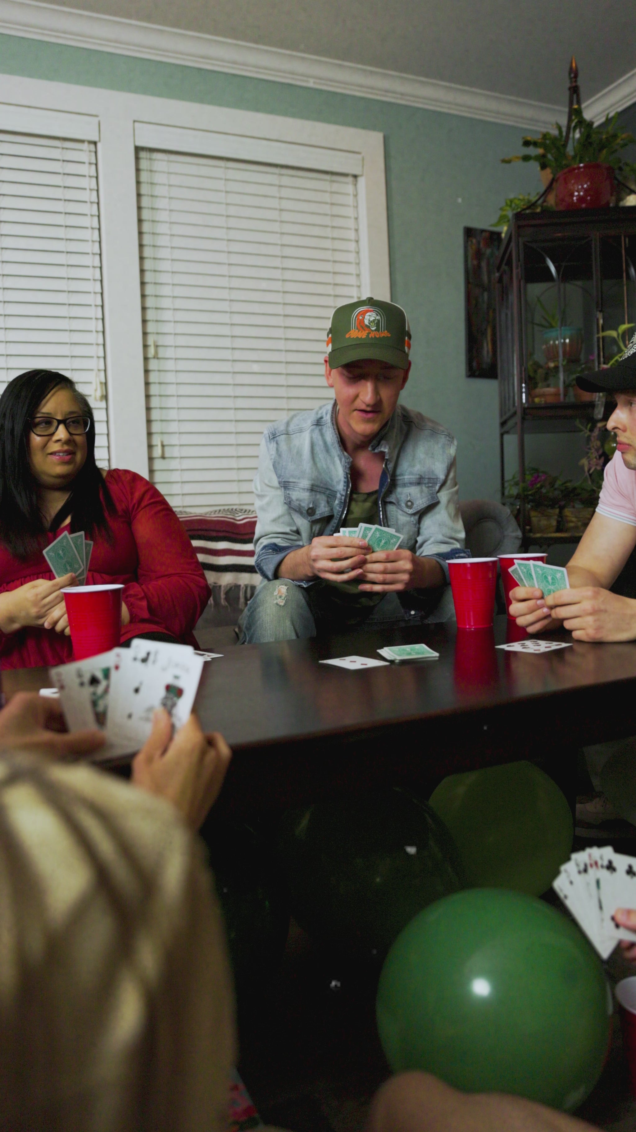 lifestyle video, friends playing a card game, features come home hat