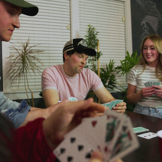 friends play card game, featuring model wearing seraph hat