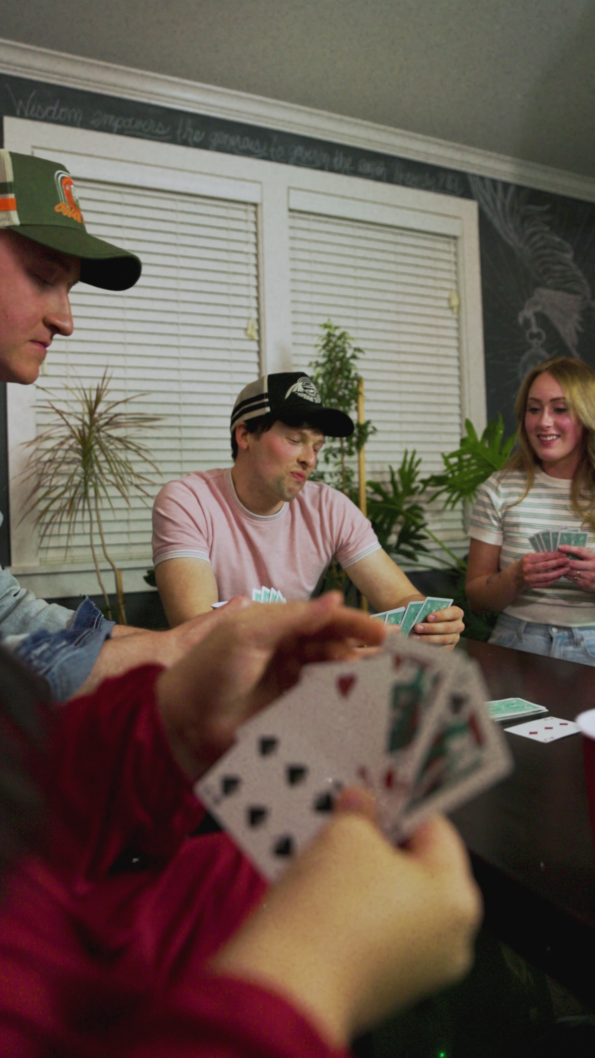 friends play card game, featuring model wearing seraph hat